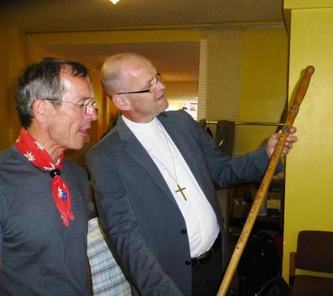 Dekan Oliver Bruckmann (r.) inspiziert den Wanderstab, den Werner Binnen durch Bayern trägt