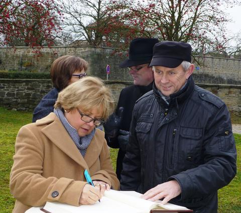 Bürgermeister Arthur Arnold ist sichtlich erfreut: Landessynodalpräsidentin Dr. Annekathrin Preidel trägt sich in das Goldene Buch Euerbachs ein; im Hintergrund: Regionabischöfin Gisela Bornowski u. Dekan Oliver Bruckmann