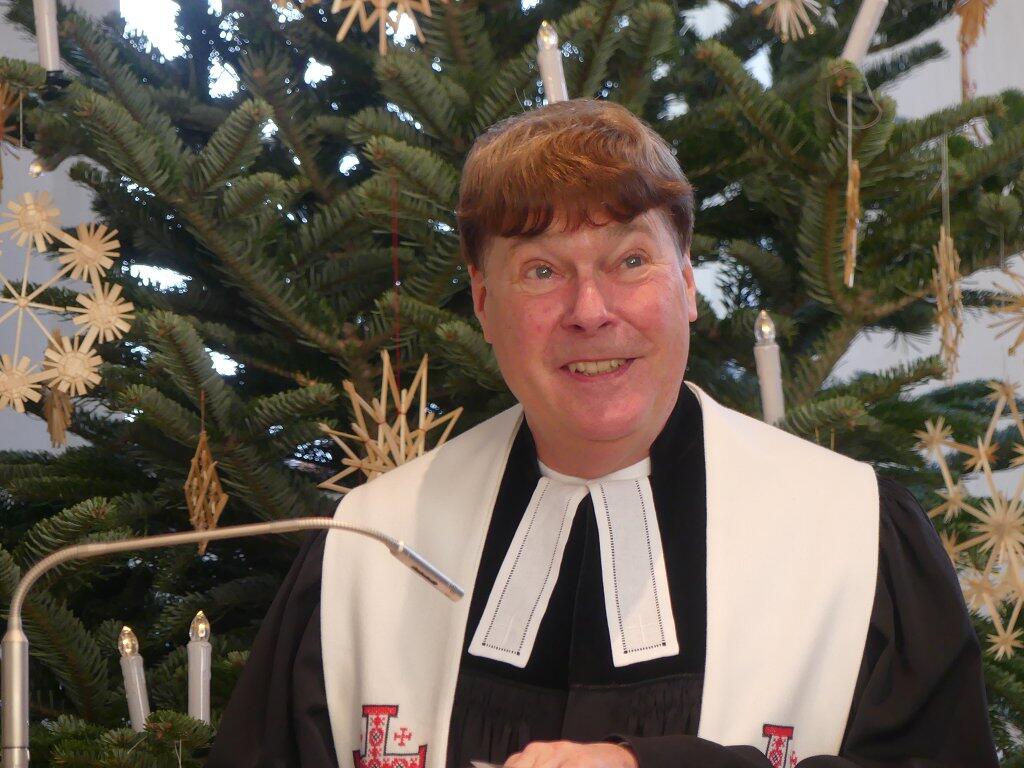 Pfarrer Martin Bauer bei seiner Verabschiedung vor dem Weihnachtsbaum