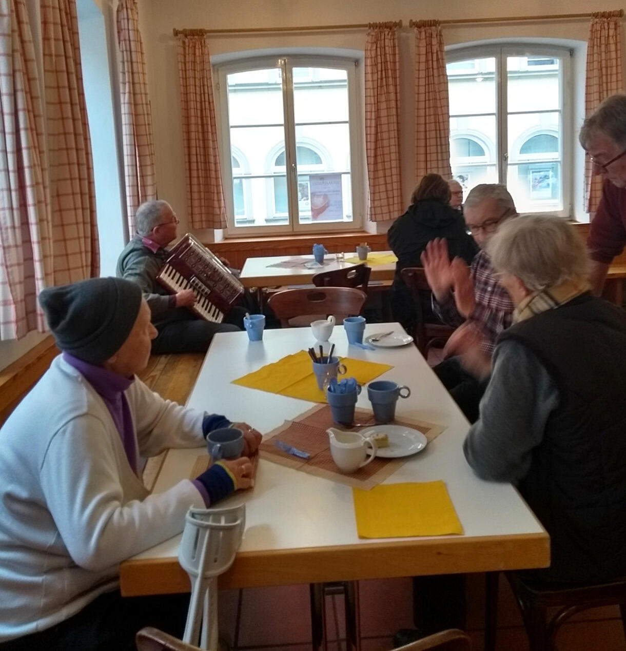 Wärmende Getränke und gute Gespräche erfreuen die Besucher:innen der „Wärme-Insel“, dabei spielt Gerd Breuer auf seinem Schifferklavier leise Hintergrundmusik.