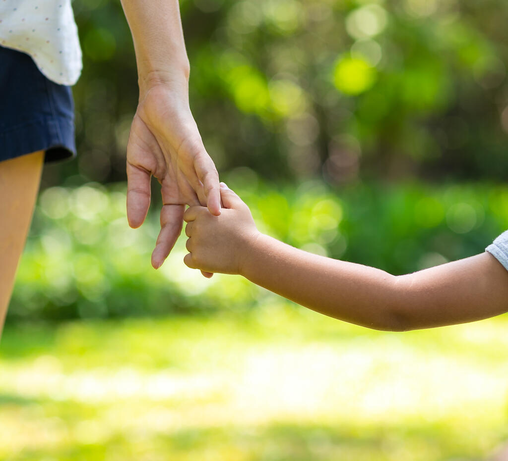 Ein Kind hält die Hand seiner Mutter