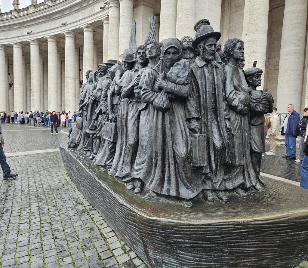 Die Skulptur "Angels unawares auf dem Petersplatz im Vatikan. 140 Flüchtlinge auf verschiedensten Kulturkreis und jeden Alters stehen dicht gedrängt auf einem angedeuteten Boot.