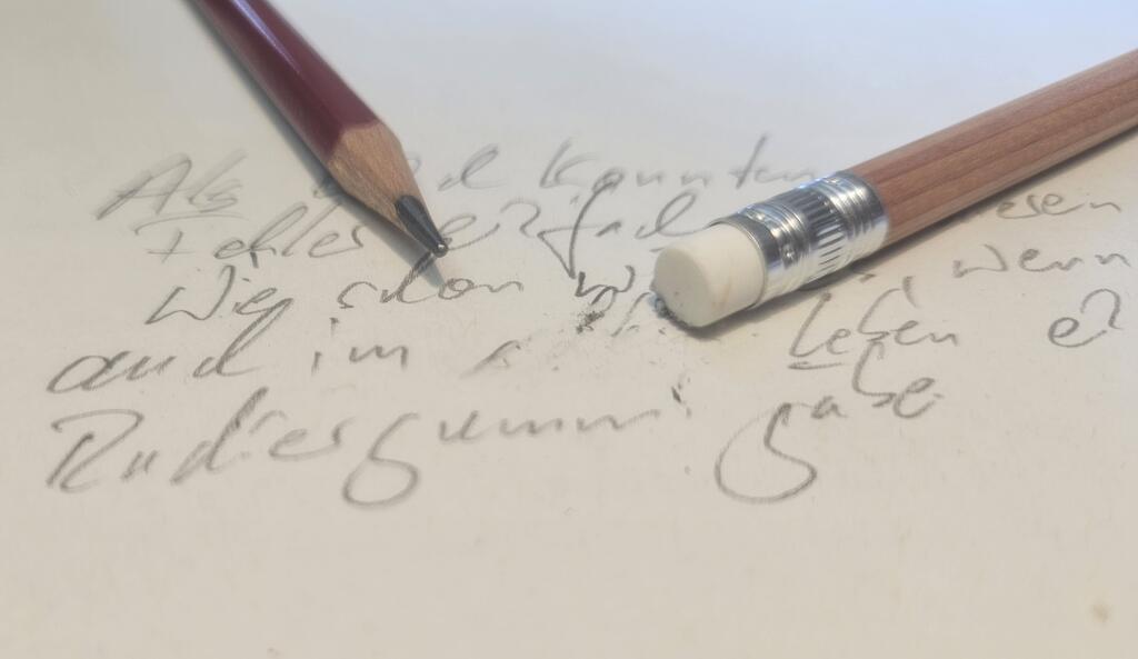 Der Text handschriftlich "Als Kind konnten wir Fehler einfach ausradieren. Wie schön wäre es, wenn es auch im (radierte Lücke) Leben einen Radiergummi gäbe." Darüber ein Bleistift und die Rückseite eines Bleistifts mit Radiergummi.