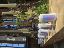 Viele Kerzen mit dem "Einfach heiraten" Logo stehen auf dem blumengeschmückten Altar