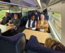 Ein Foto vom Pfarrkonvent 2024. Im Zugabteil sitzen von links nach rechts: Ivar Brückner, Lina Spiegel, Mulugeta Giragn Aga, Dekan Oliver Bruckmann. In der Reihe dahinter Thomas Volk.