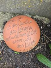 Ein runder Stein mit dem Text: "Bei dir ist die Quelle des Lebens"