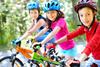 Mehrere Kinder auf Fahrrädern mit Helm