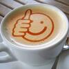 Eine Tasse Kaffe mit einem Smiley mit Daumen hoch