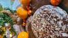 Lebkuchen, Mandarinen und kleine Schokokügelchen auf einem Teller. Im Hintergrund ein kleiner Tannenbaum.