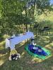 Ein Altar im Freien am See, davor sitzen zwei Handpuppen